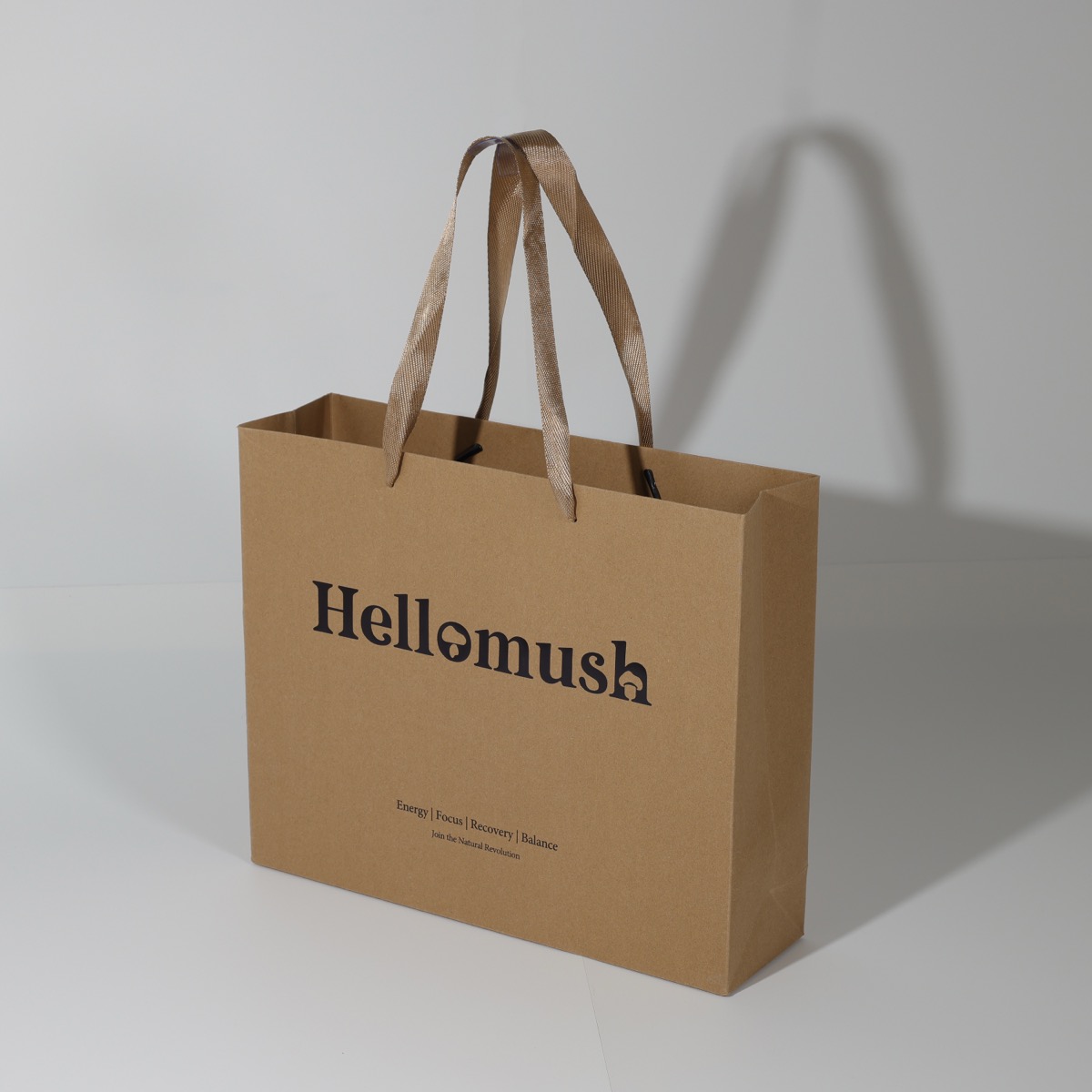 Hellomush — kraft luxury shopping bag with die-cut logo print and herringbone ribbon handles
